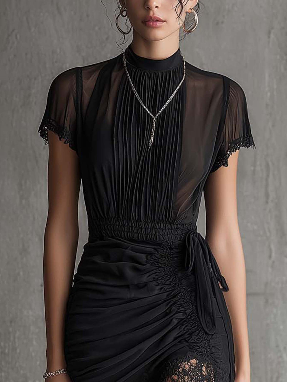 Mini-robe noire en mousseline plissée à la taille, ornée de dentelle
