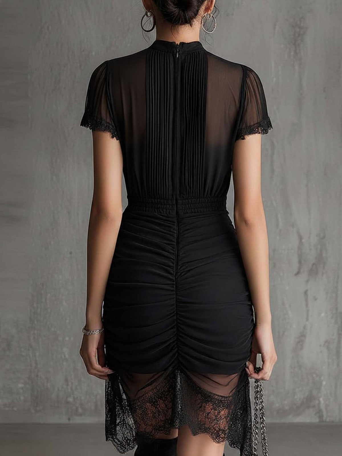 Mini-robe noire en mousseline plissée à la taille, ornée de dentelle