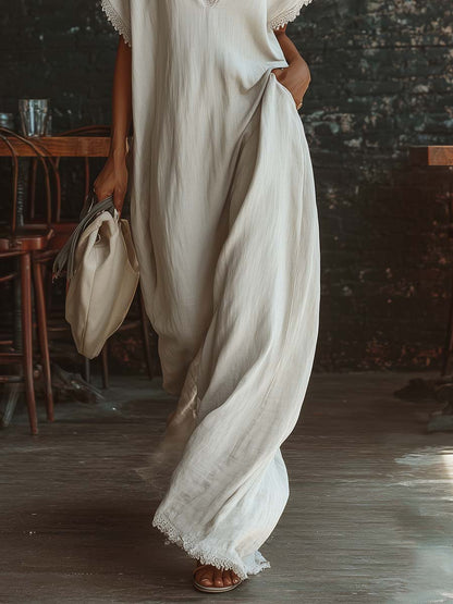 Urban white cotton maxi dress with a V-neck, short sleeves, and lace trim, casual bohemian style